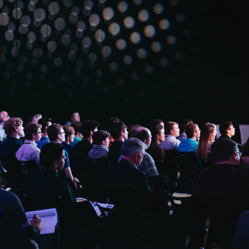 A group of several people sitting as an audience in a conference
