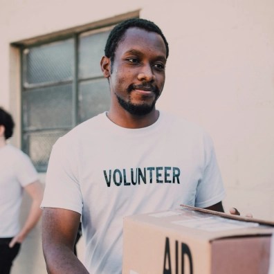 A volunteer carrying a box of donations