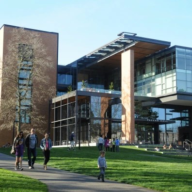A picture of a modern looking building with families walking outside