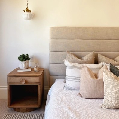 A picture of a bedroom with a nightstand and half of the bed