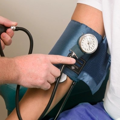 Someone taking the blood pressure on someone else's arm