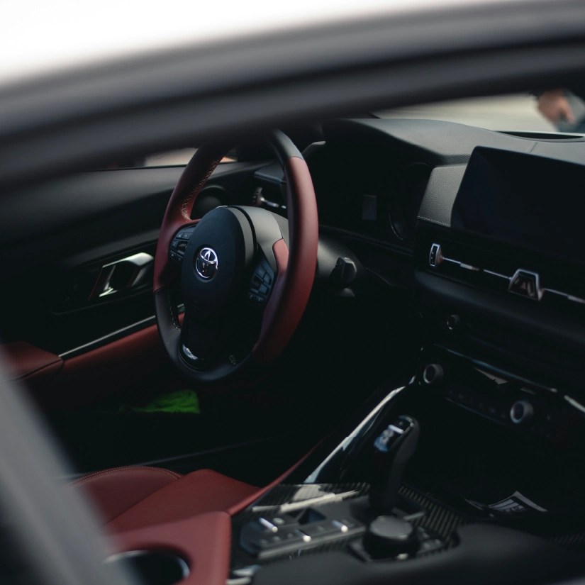 Interior of a Toyota vehicle with red leather seats and a black screen