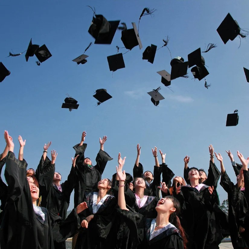 Graduates throwing their graduate caps into the air