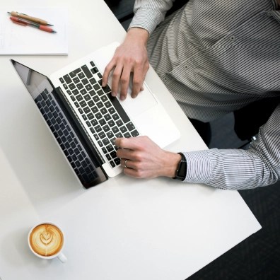 Overhead view of someone working at a desk on a laptop