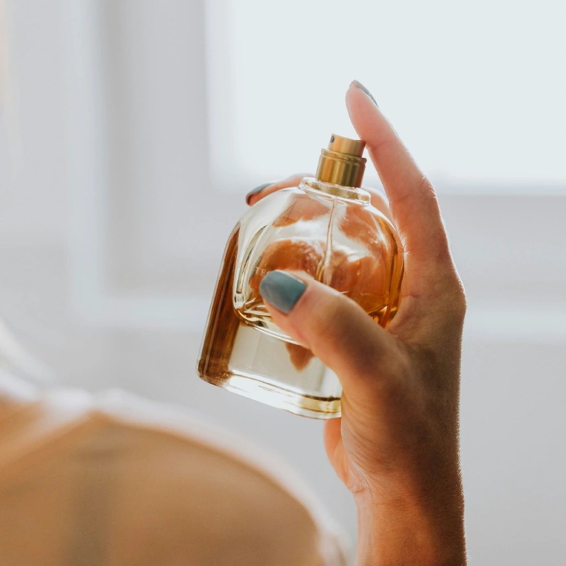 Closeup of someone spritzing perfume on themselves