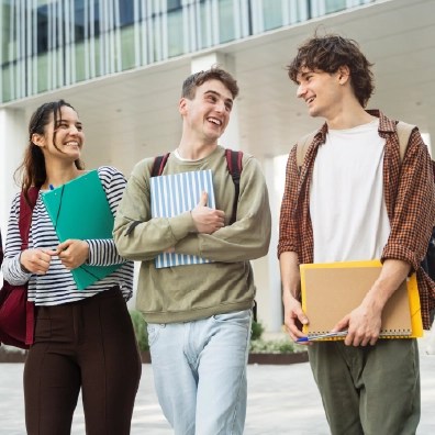 University students holding notebooks and walking together