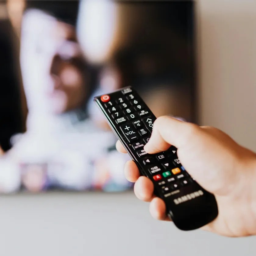 Hand holding a remote control for a television